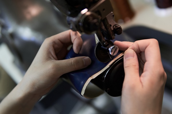 革をミシンで縫う人